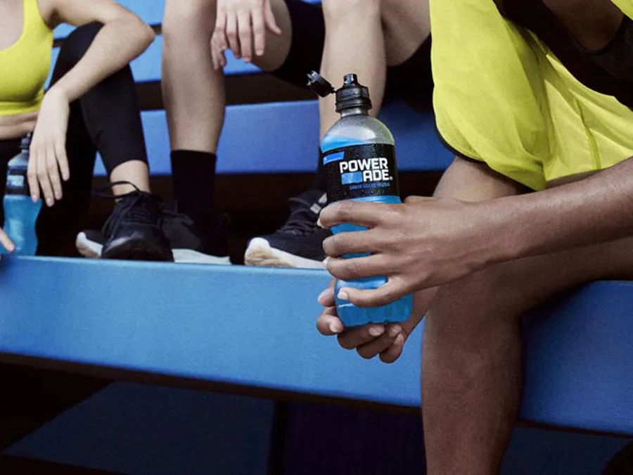 Um grupo de atletas sentados em uma arquibancada bebendo Powerade