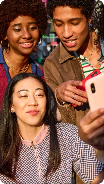 A group of friends looking at a mobile device.
