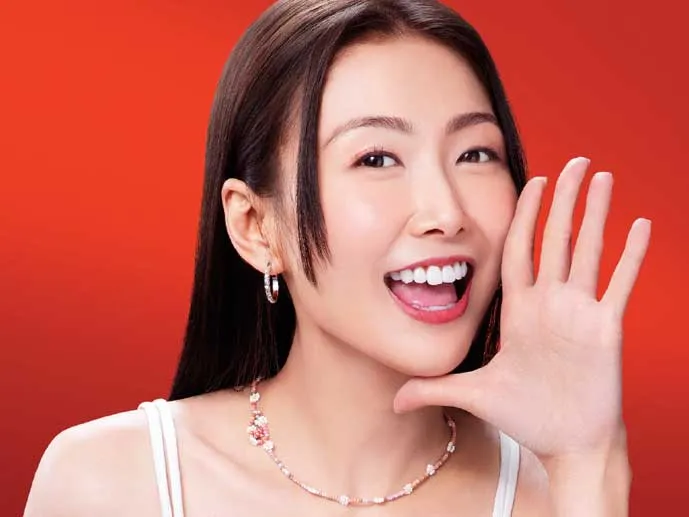 A woman waves to the camera in a promotional image for UA Finance.