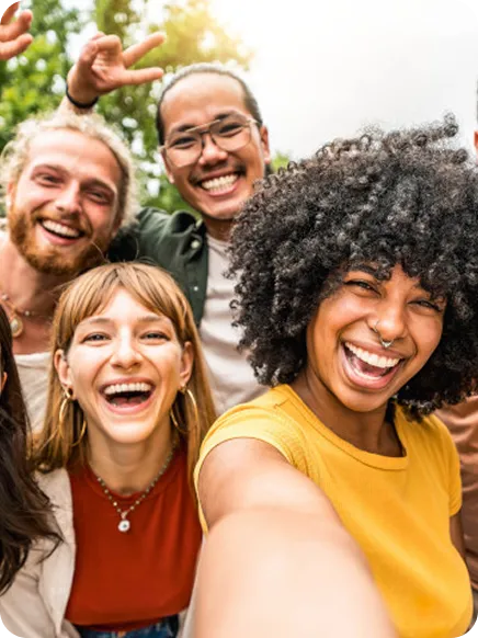 duas amigas rindo na praia enquanto usam o whatsapp para se conectar com amigos e familiares